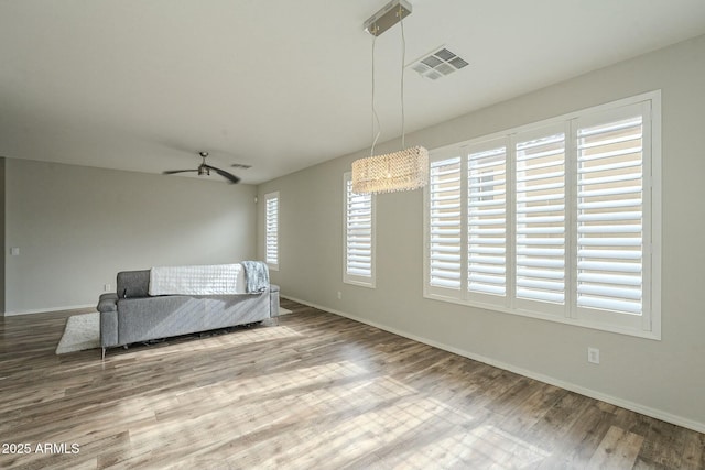 unfurnished room with visible vents, baseboards, and wood finished floors