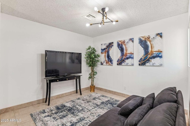 tiled living room featuring an inviting chandelier and a textured ceiling