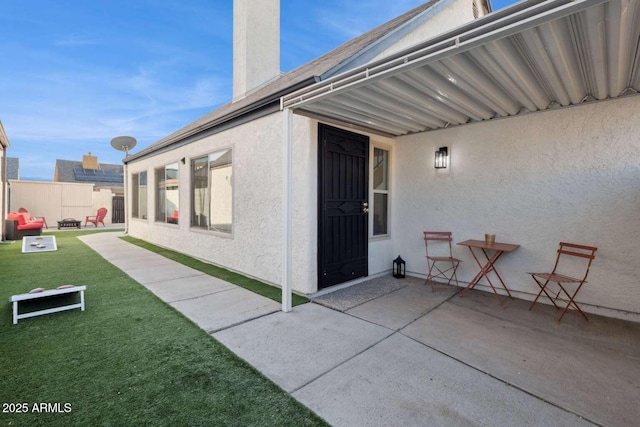 doorway to property with a lawn and a patio