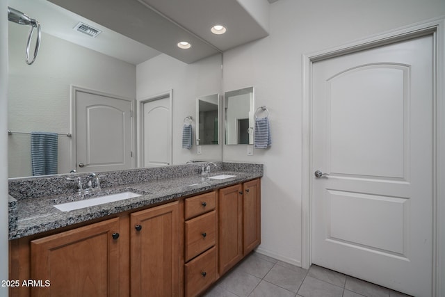 bathroom featuring visible vents, a sink, tile patterned floors, and double vanity