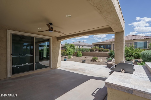 view of patio featuring fence, a ceiling fan, and exterior kitchen