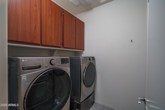laundry room featuring baseboards, cabinet space, tile patterned floors, and washing machine and clothes dryer