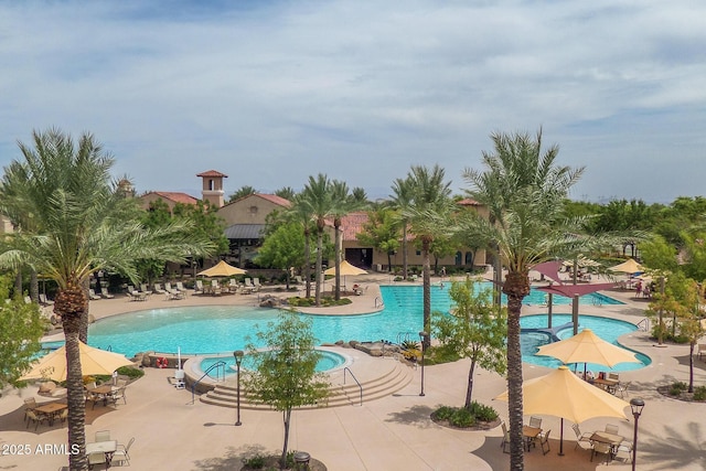 community pool with a patio and a hot tub