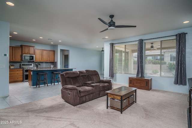 living room with light tile patterned floors, light carpet, a ceiling fan, and recessed lighting