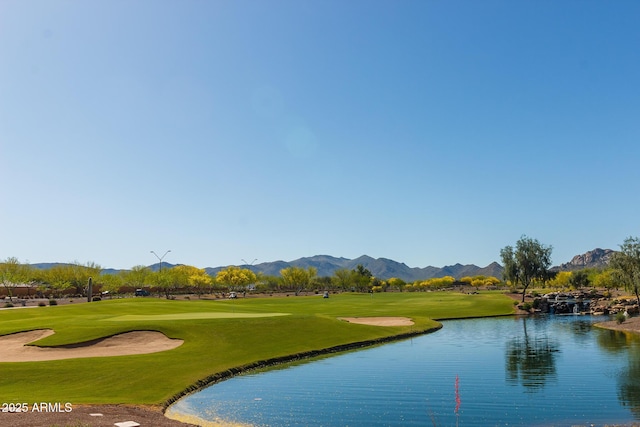 surrounding community featuring a yard, a water and mountain view, and golf course view