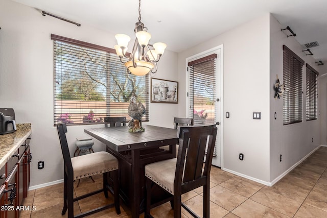 dining space with an inviting chandelier, baseboards, visible vents, and light tile patterned flooring