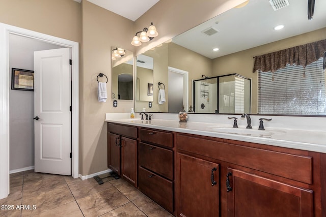 bathroom with double vanity, visible vents, and a sink