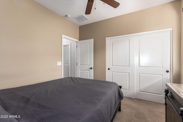 bedroom featuring a ceiling fan, a closet, visible vents, and light carpet