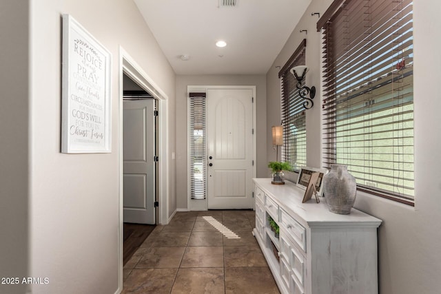 entrance foyer featuring dark tile patterned floors and baseboards