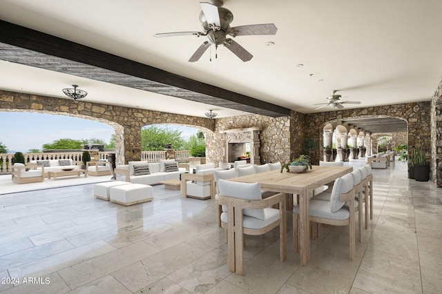 view of patio with an outdoor living space with a fireplace and ceiling fan