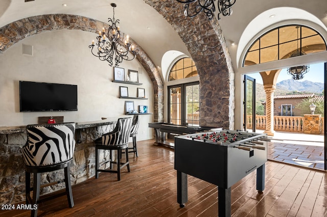 recreation room featuring a high ceiling, a mountain view, dark hardwood / wood-style flooring, and a notable chandelier