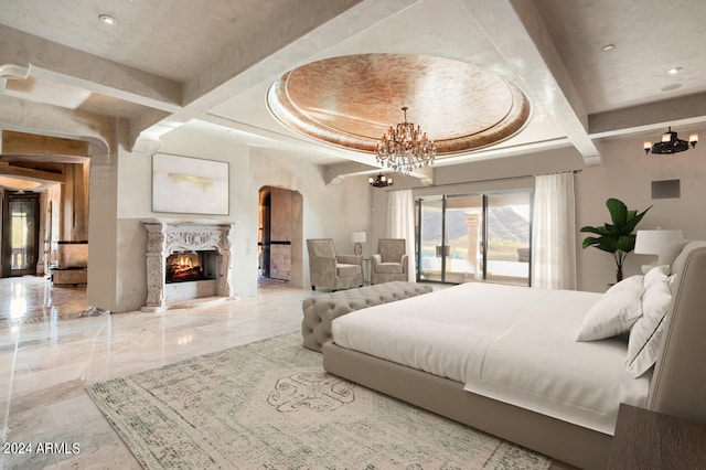 bedroom with a fireplace, beam ceiling, and a notable chandelier