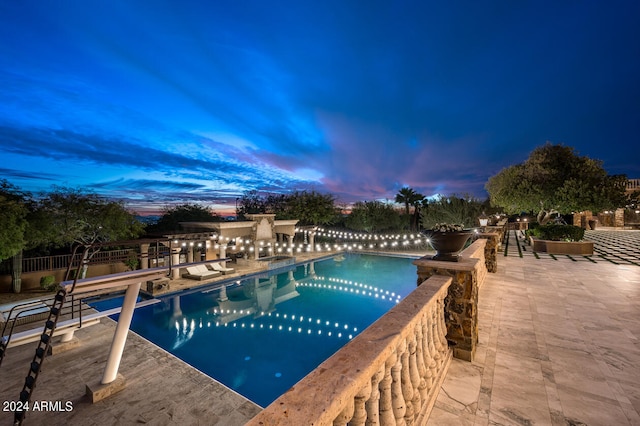 pool at dusk featuring a patio area