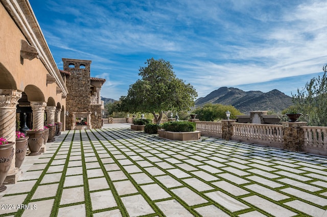 view of patio / terrace featuring an outdoor stone fireplace and a mountain view