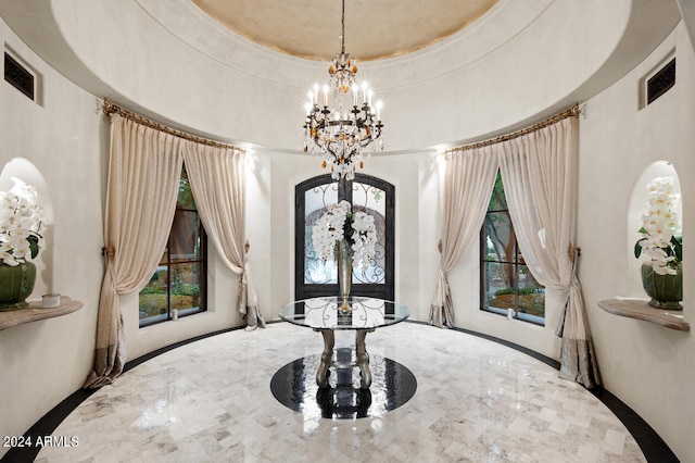 dining space featuring a raised ceiling and an inviting chandelier