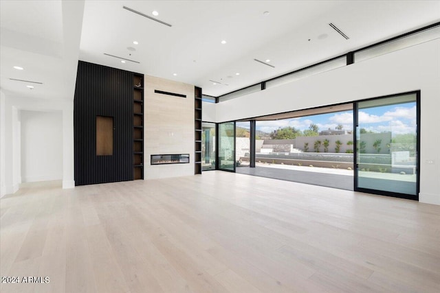 unfurnished living room with a fireplace and light wood-type flooring