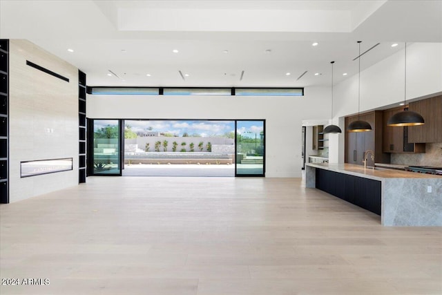 kitchen with plenty of natural light, white cabinets, backsplash, and pendant lighting