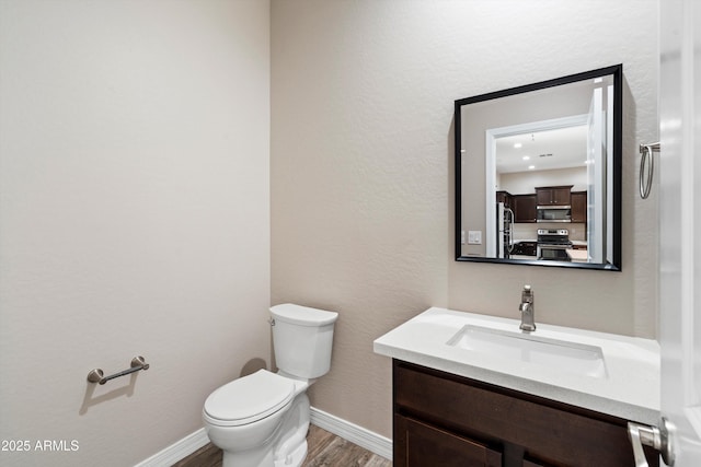 3010 N 37th St Unit 6, Phoenix, AZ 85018 - bathroom with wood finished floors, toilet, vanity, and baseboards