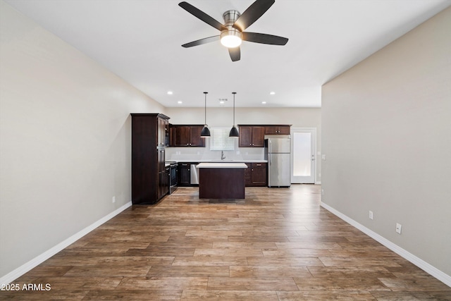 3010 N 37th St Unit 6, Phoenix, AZ 85018 - kitchen featuring stainless steel appliances, dark brown cabinetry, a ceiling fan, a center island, and baseboards