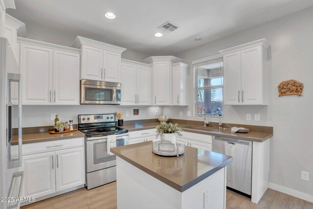 242 N Crosscreek Dr, Chandler, AZ 85225 - kitchen with stainless steel appliances, a sink, white cabinetry, light wood-style floors, and recessed lighting