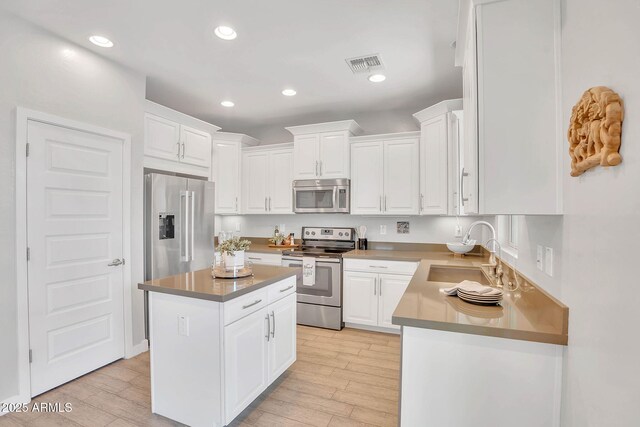 242 N Crosscreek Dr, Chandler, AZ 85225 - kitchen featuring stainless steel appliances, a sink, white cabinetry, light wood-style flooring, and recessed lighting