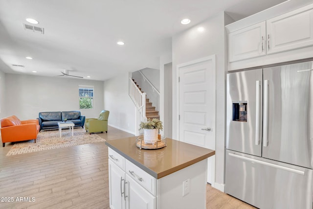 242 N Crosscreek Dr, Chandler, AZ 85225 - kitchen with stainless steel fridge with ice dispenser, light wood-type flooring, a kitchen island, white cabinetry, and open floor plan