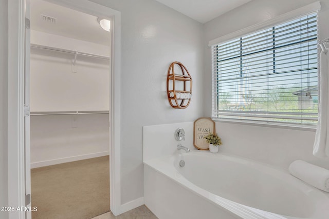 242 N Crosscreek Dr, Chandler, AZ 85225 - bathroom featuring a garden tub, a spacious closet, and baseboards