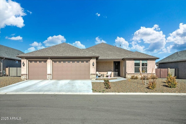 view of front of home featuring concrete driveway, an attached garage, stone siding, and stucco siding