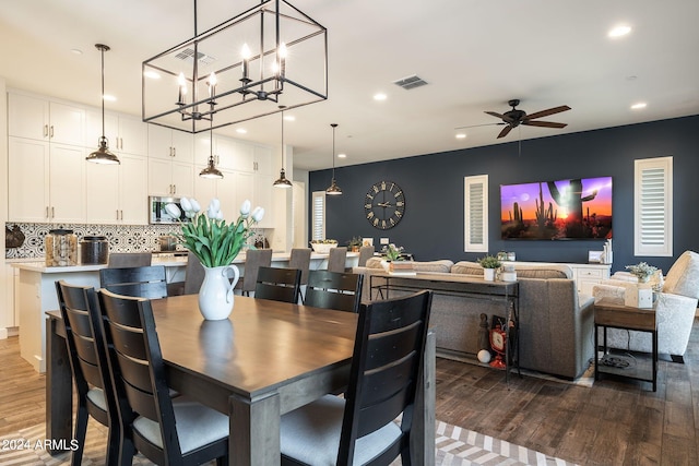 dining area with dark wood-type flooring and ceiling fan