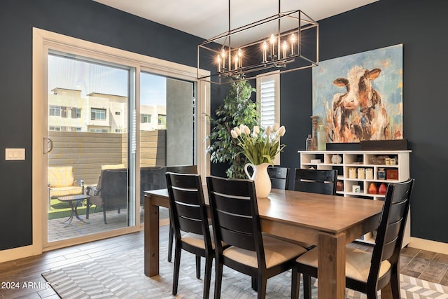 dining space featuring hardwood / wood-style floors and an inviting chandelier