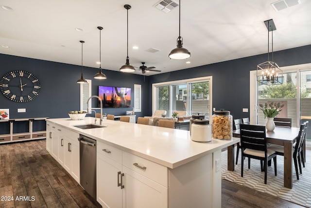 kitchen with pendant lighting, a kitchen island with sink, sink, and white cabinets