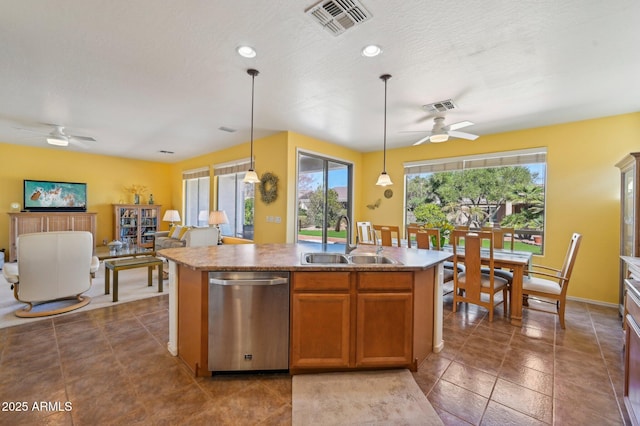 kitchen with a sink, visible vents, stainless steel dishwasher, and an island with sink