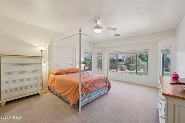 bedroom featuring a ceiling fan, light colored carpet, and visible vents