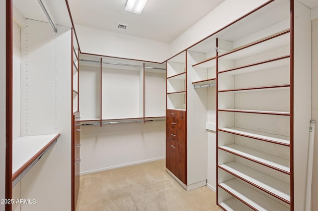 walk in closet featuring visible vents and light colored carpet