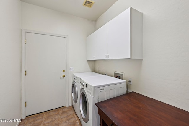 washroom with separate washer and dryer, cabinet space, and visible vents