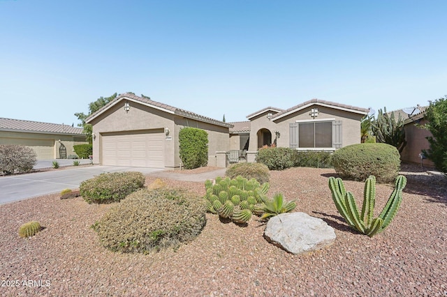 mediterranean / spanish home featuring a garage, a tile roof, driveway, and stucco siding