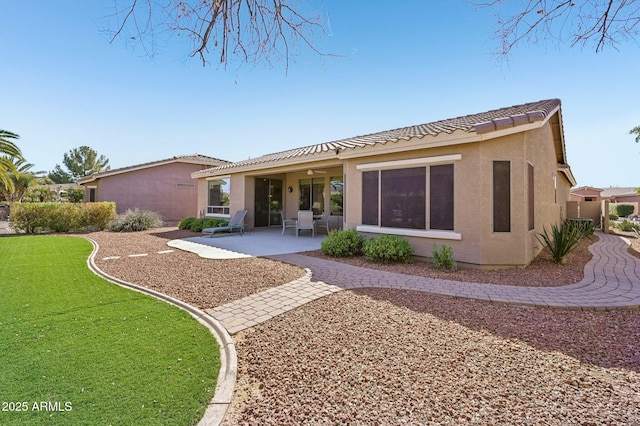 view of front of home with a patio area, a tile roof, and stucco siding