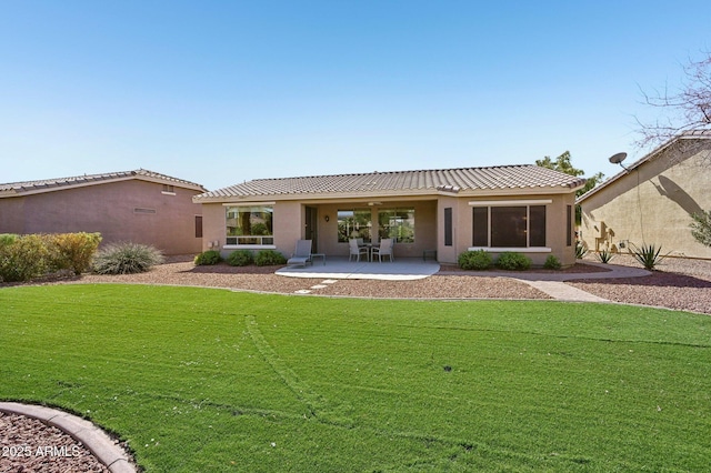 back of house with a patio area, a tile roof, a lawn, and stucco siding