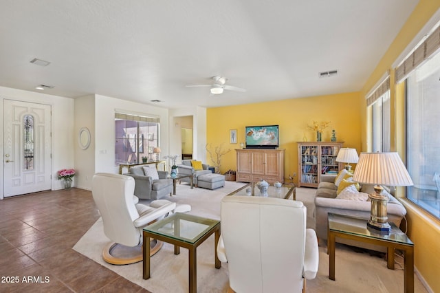 tiled living room with visible vents and ceiling fan