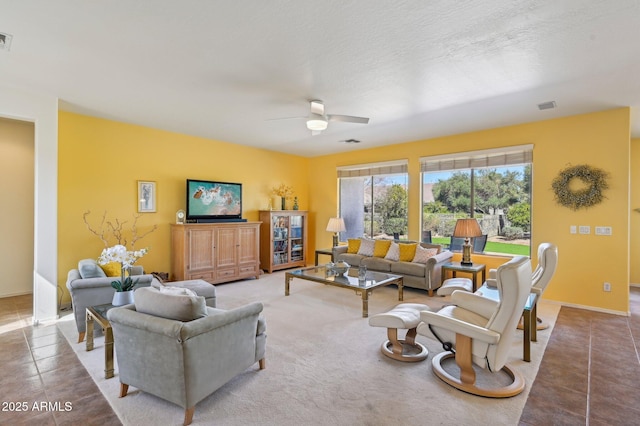 tiled living area with a textured ceiling, visible vents, and a ceiling fan