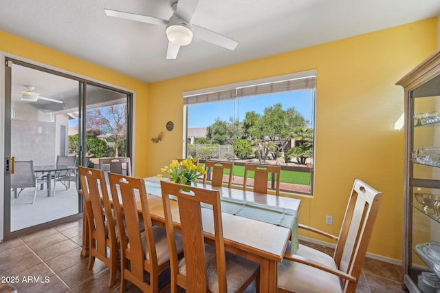 dining space featuring baseboards, a ceiling fan, and tile patterned floors