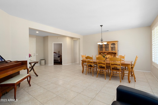 dining area featuring a notable chandelier and light tile patterned flooring