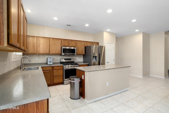 kitchen featuring appliances with stainless steel finishes, sink, a kitchen island, light stone counters, and light tile patterned floors