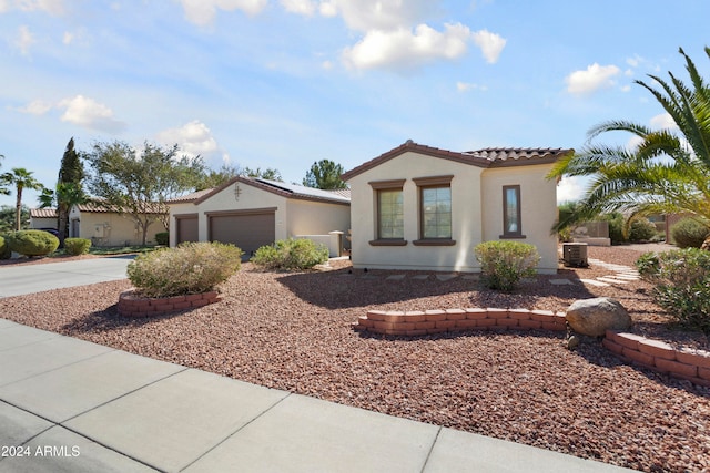 mediterranean / spanish-style house with central AC unit and a garage