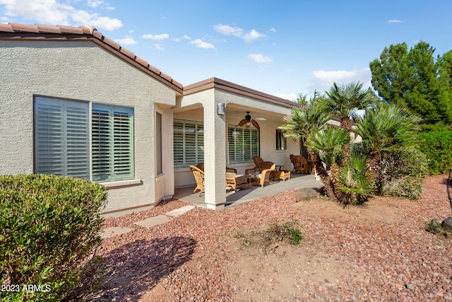 rear view of property with a patio area and ceiling fan