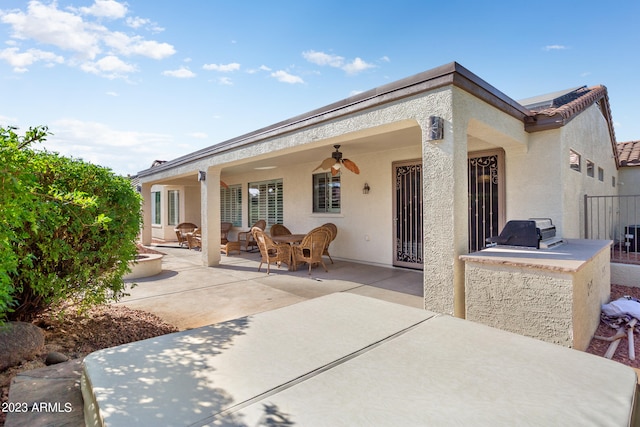 rear view of property featuring a patio area and ceiling fan