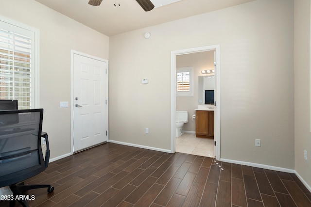 unfurnished office with ceiling fan and dark hardwood / wood-style floors