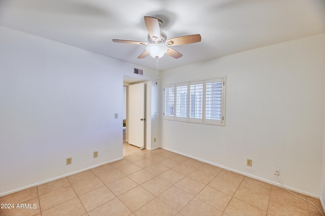 tiled spare room featuring ceiling fan