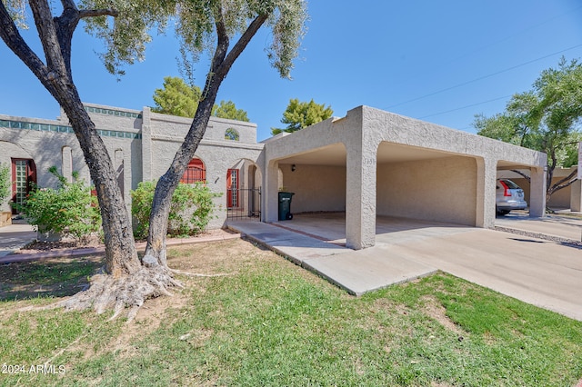 view of front of house with a front yard and a carport