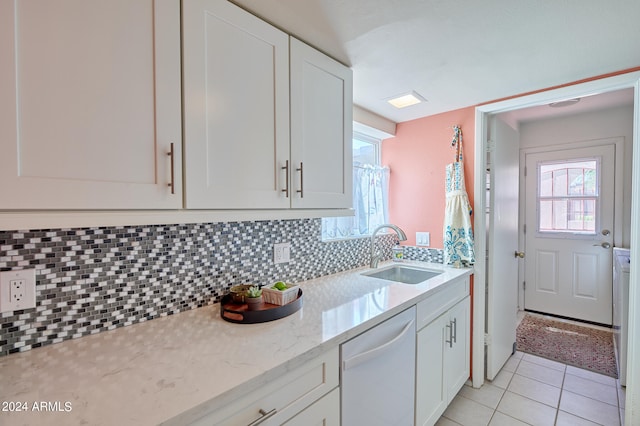 kitchen with sink, backsplash, white cabinetry, dishwasher, and light stone countertops